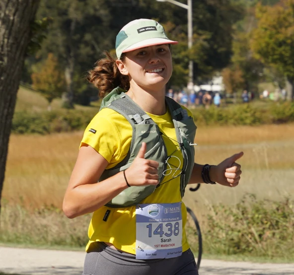 Runner giving two thumbs up during her first marathon